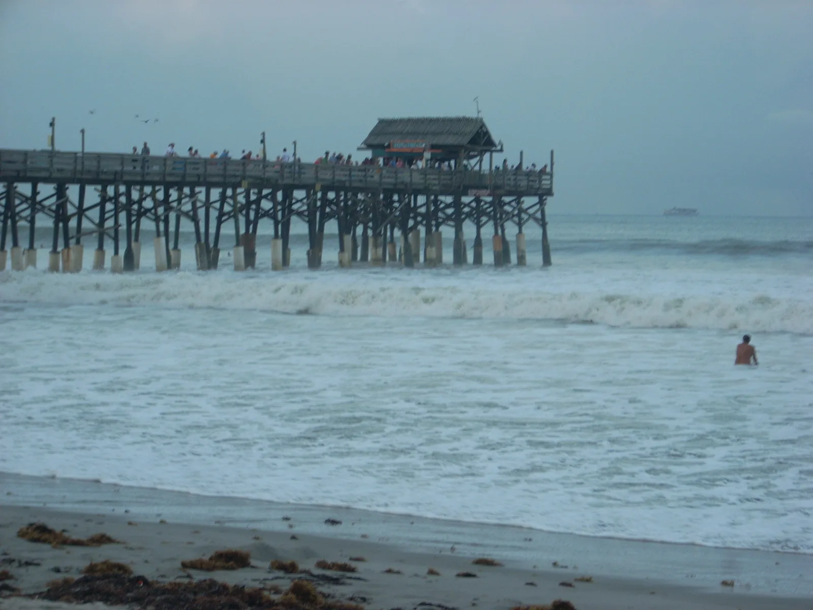 Whitewater from a large swell running out to the end of the Cocoa Beach Pier on an overcast day
