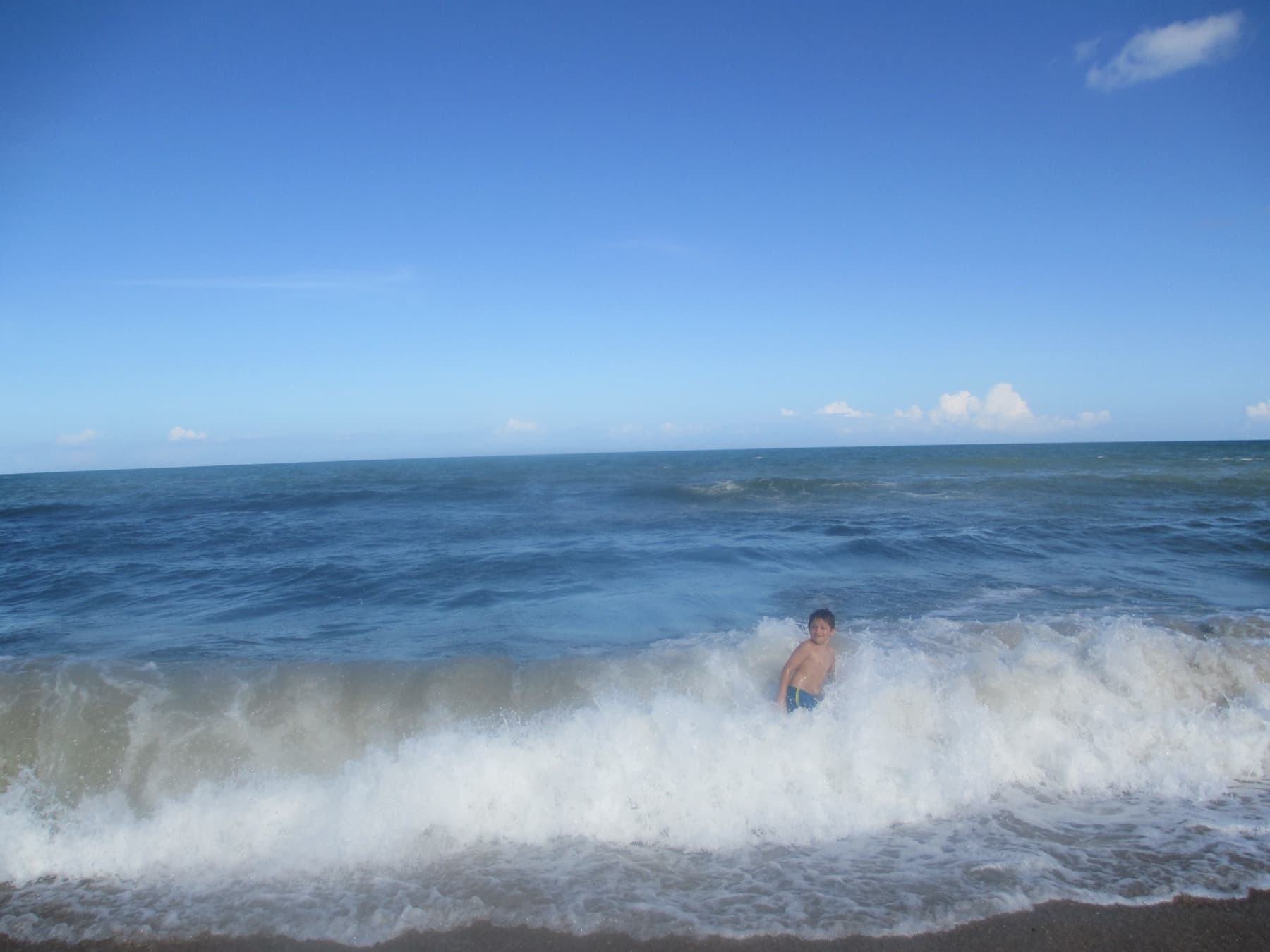 Small surf rolling into Carolina Beach under bright North Carolina sun.