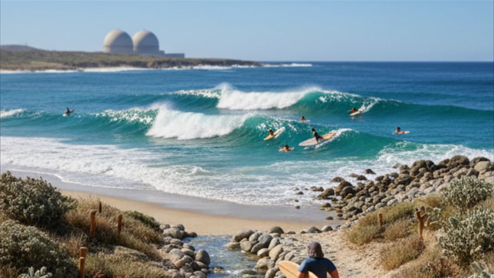 Clean waves breaking with surfers in the lineup